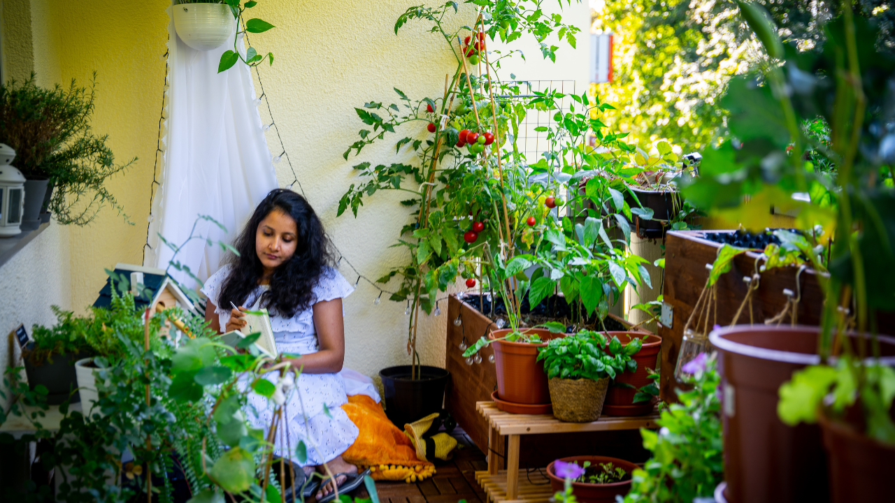 Aparna sitting in her balcony garden surrounded by plants